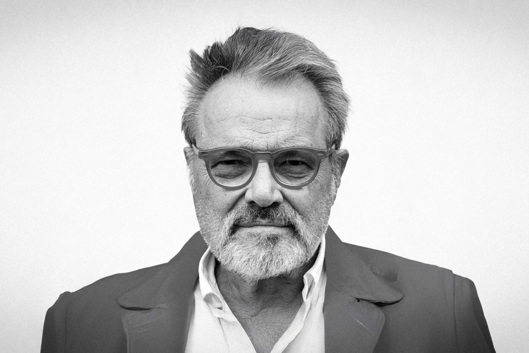 Un ritratto di Oliviero Toscani con una delle sue fotografie iconiche.