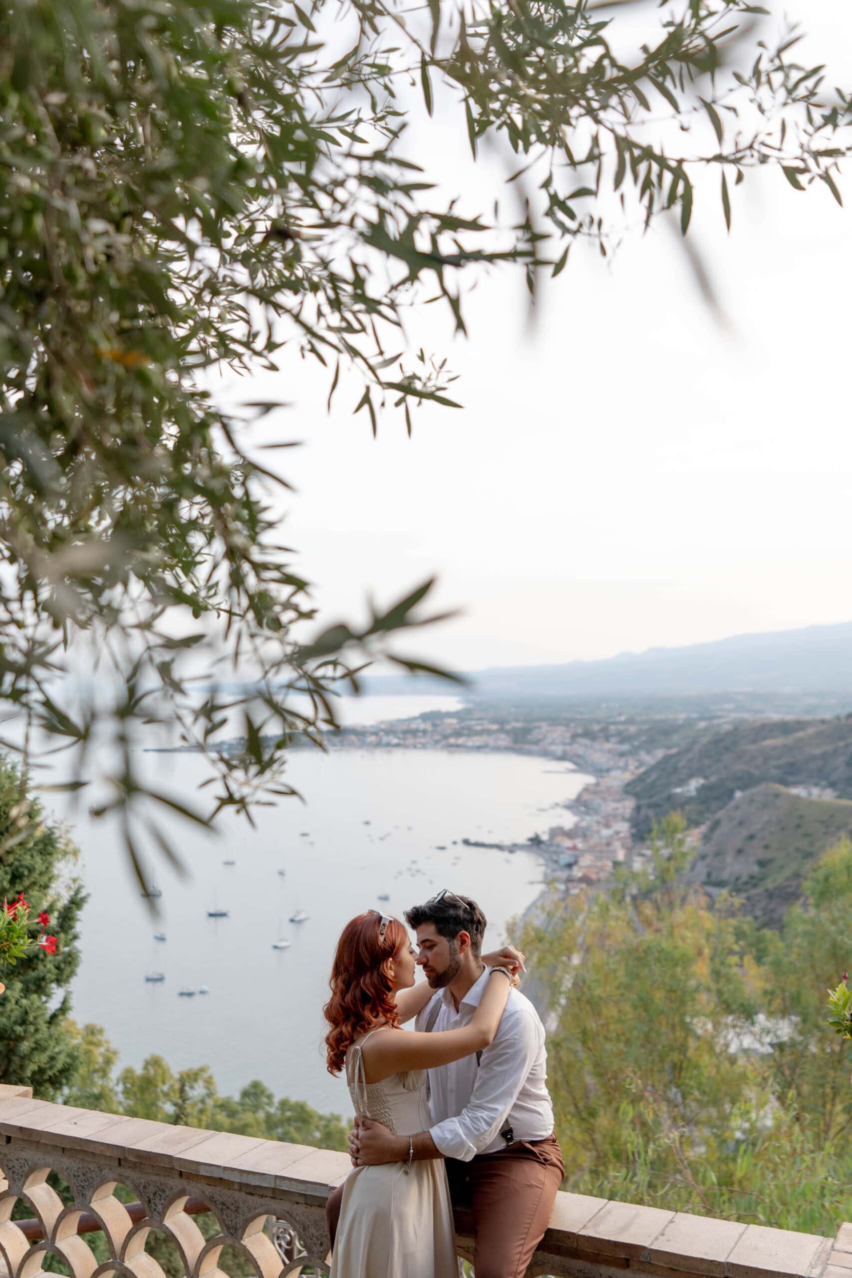 Engagement romantico a Taormina, coppia tra luce mediterranea e architettura storica della città.